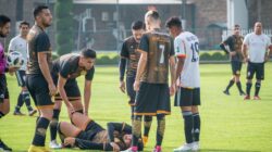 Pemain berkumpul di sekitar rekan satu tim yang terluka selama pertandingan sepak bola di Texcoco, Meksiko.