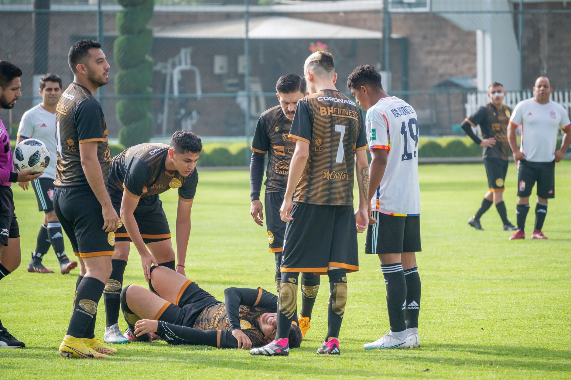 Pemain berkumpul di sekitar rekan satu tim yang terluka selama pertandingan sepak bola di Texcoco, Meksiko.