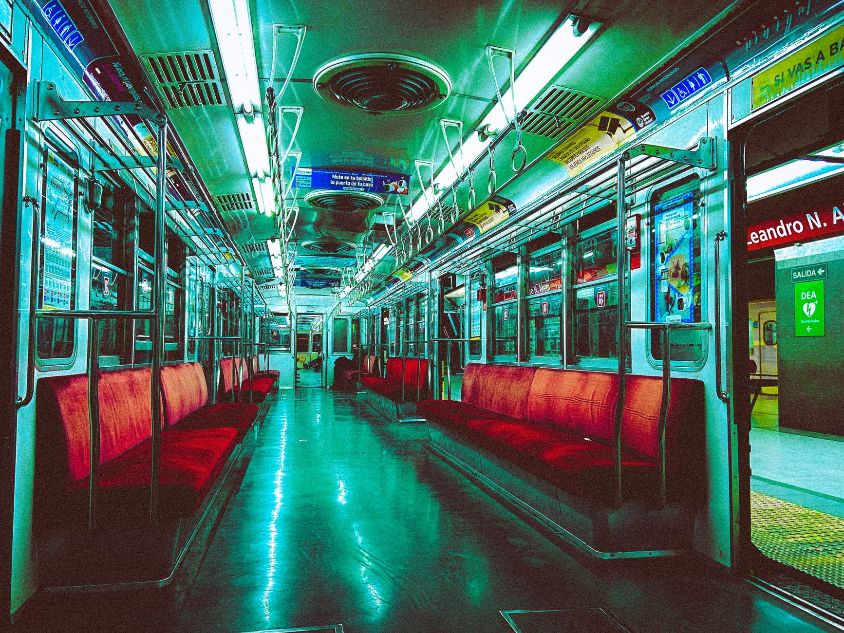 Interior cerah dari kereta bawah tanah Buenos Aires di malam hari, menampilkan transportasi publik modern.