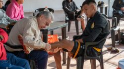Seorang pelatih merawat cedera pemain sepak bola, memberikan dukungan dan perawatan selama latihan.