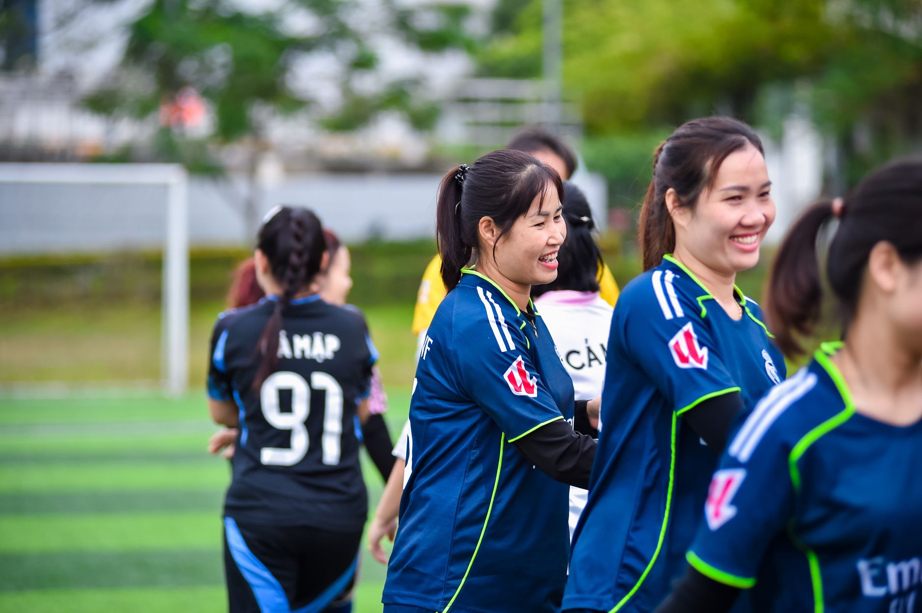 Suasana meriah tim sepak bola wanita yang merayakan kemenangan di lapangan di Hà Nội, Việt Nam.