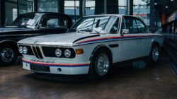 Pameran mobil vintage di dalam ruangan, menekankan desain klasik dan sejarah otomotif.