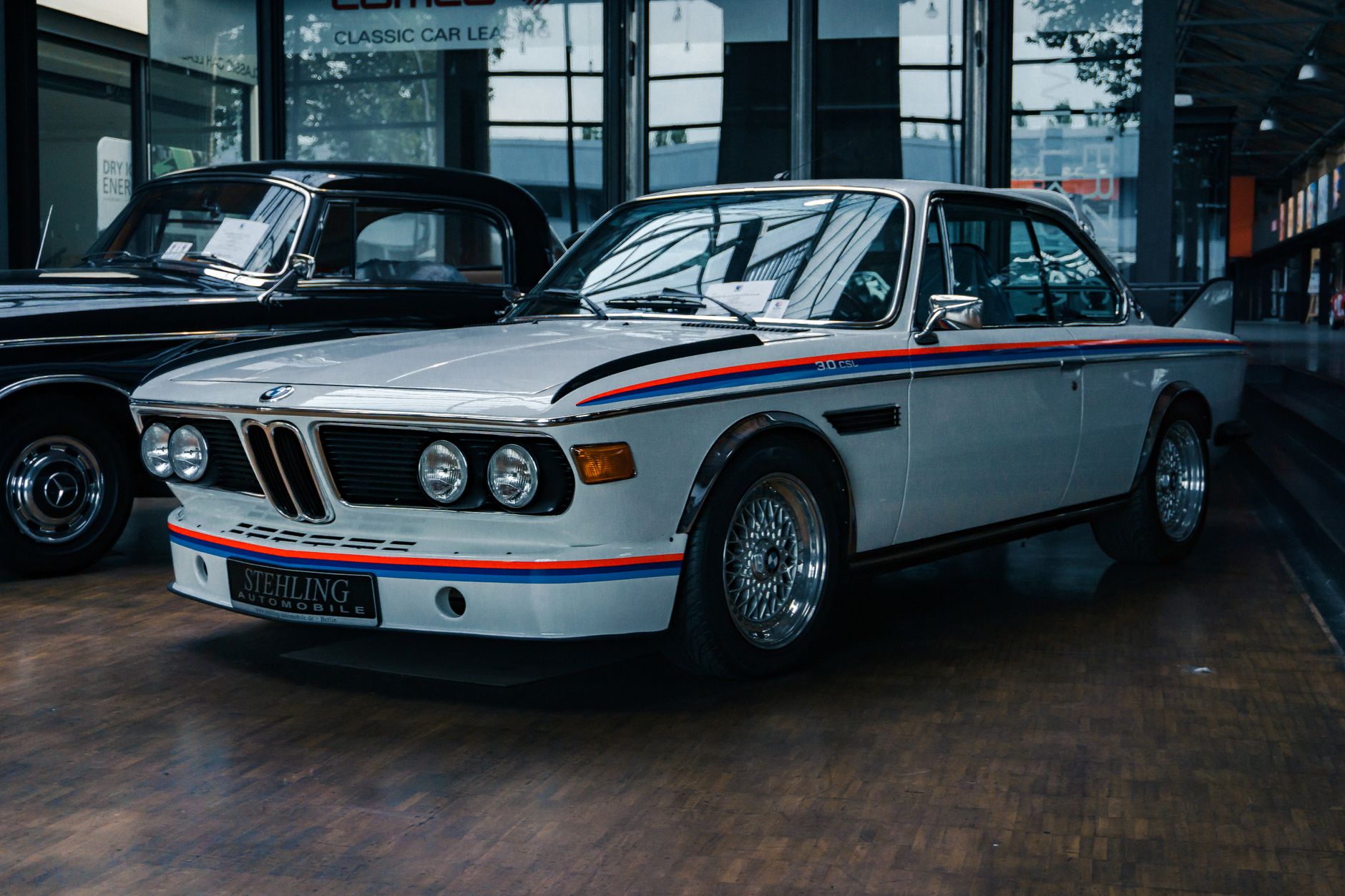 Pameran mobil vintage di dalam ruangan, menekankan desain klasik dan sejarah otomotif.
