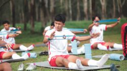 Sekelompok pemain sepak bola muda berlatih dengan band resistensi di luar ruangan di Jakarta, Indonesia.