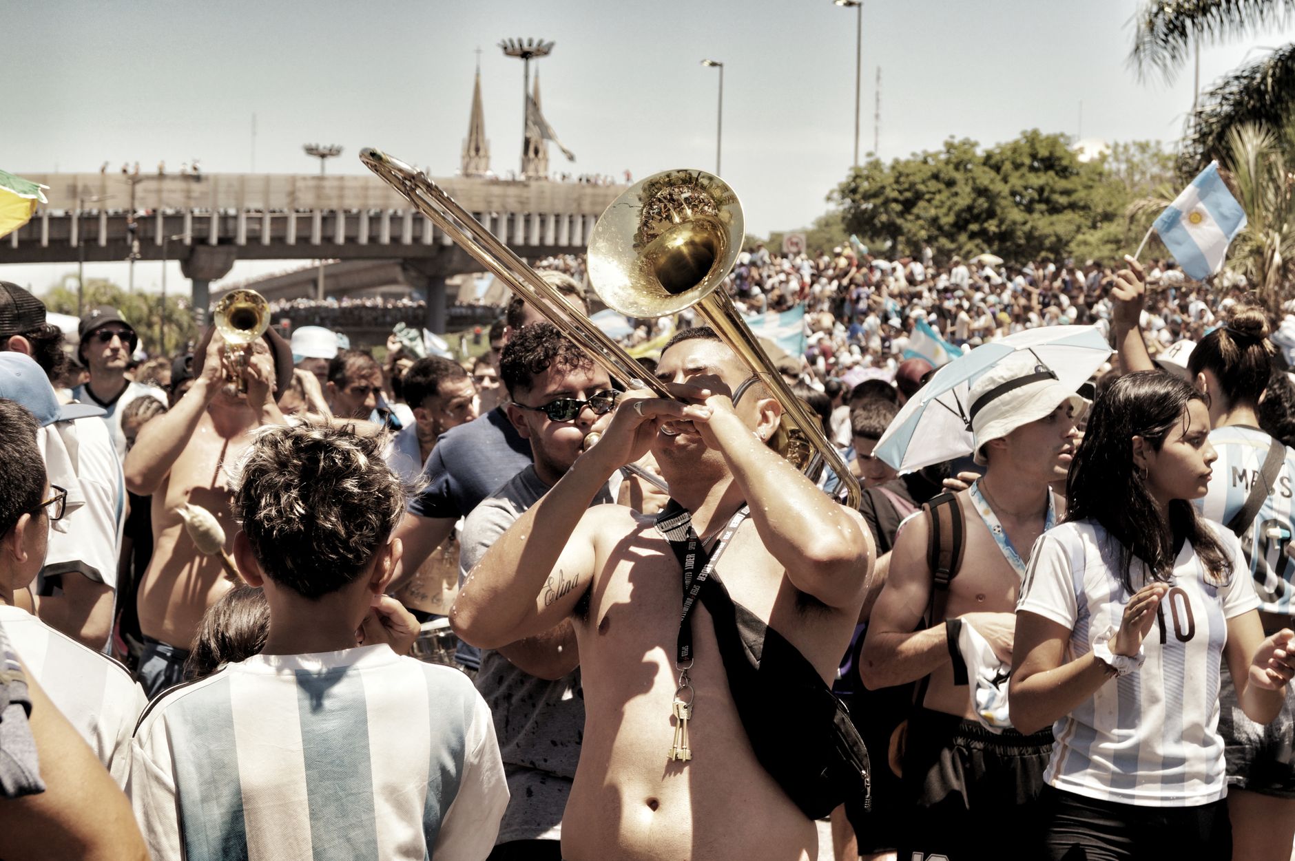 Perayaan jalan yang meriah di Buenos Aires dengan alat musik dan penggemar olahraga.