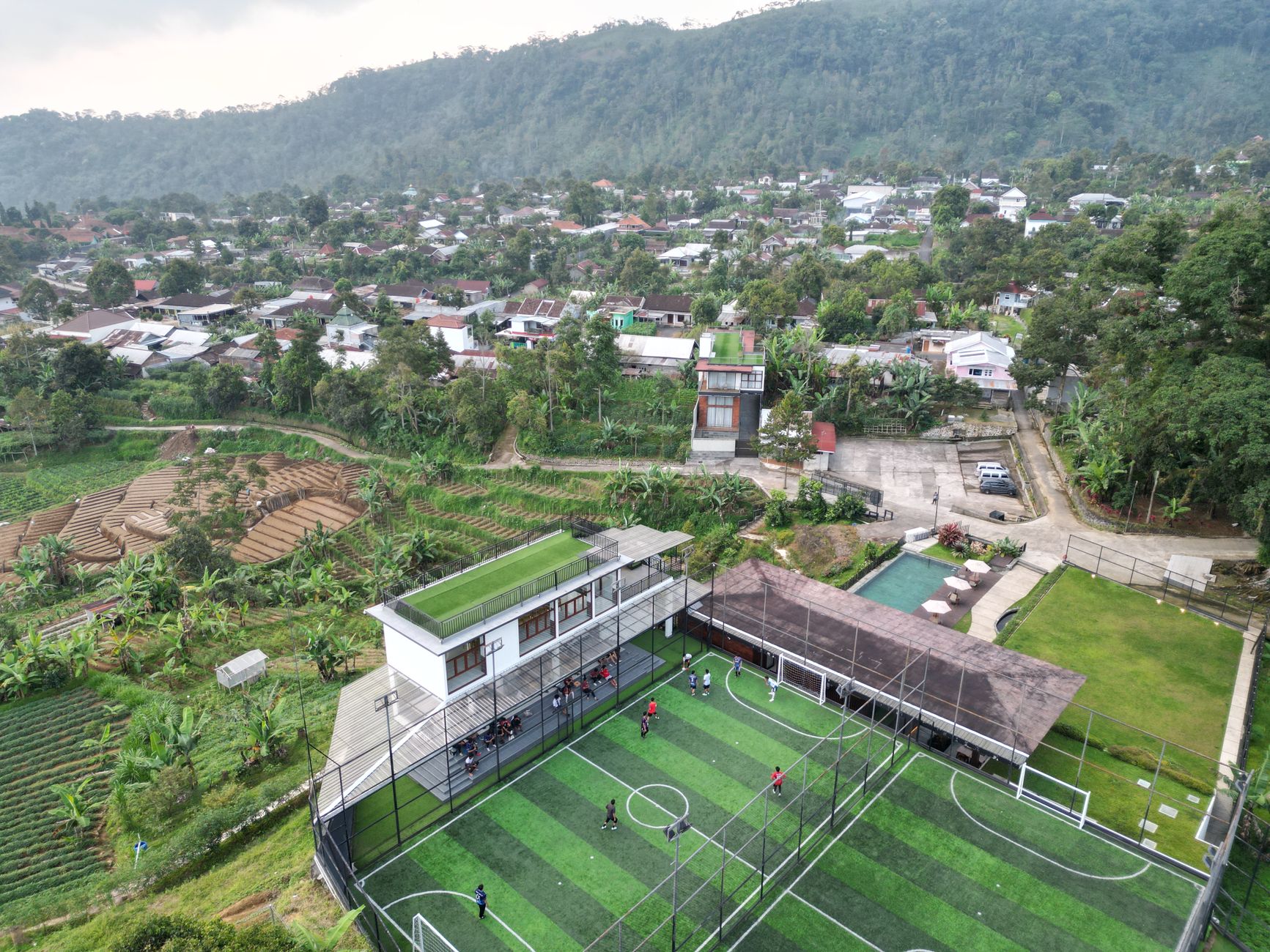 Pemandangan udara yang memperlihatkan lapangan sepak bola dan desa sekitarnya di Jawa Tengah, Indonesia.