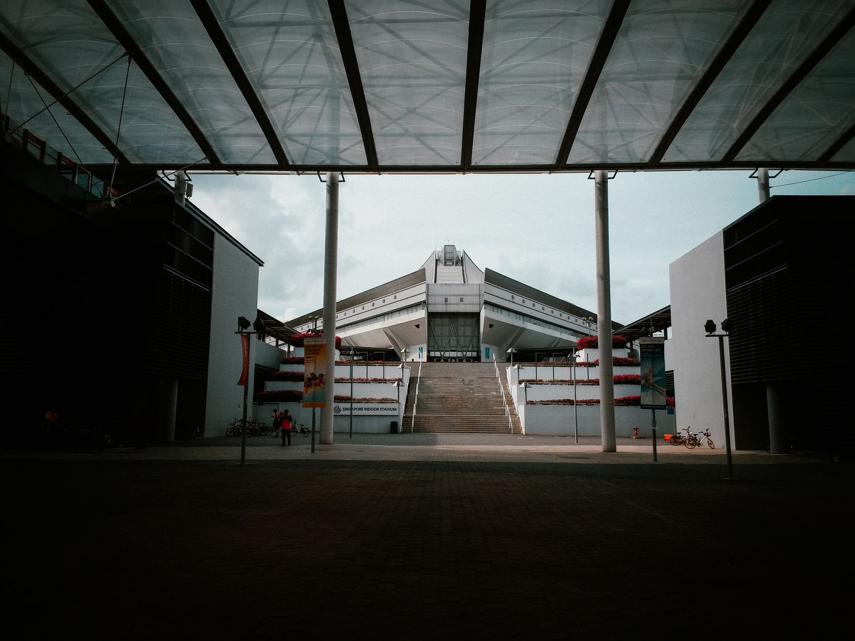 Struktur arsitektur modern yang mencolok dengan desain brutalistis dan simetri, sempurna untuk visual eksplorasi perkotaan.
