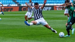 Pertandingan sepak bola yang seru dengan para pemain beraksi di lapangan hijau.