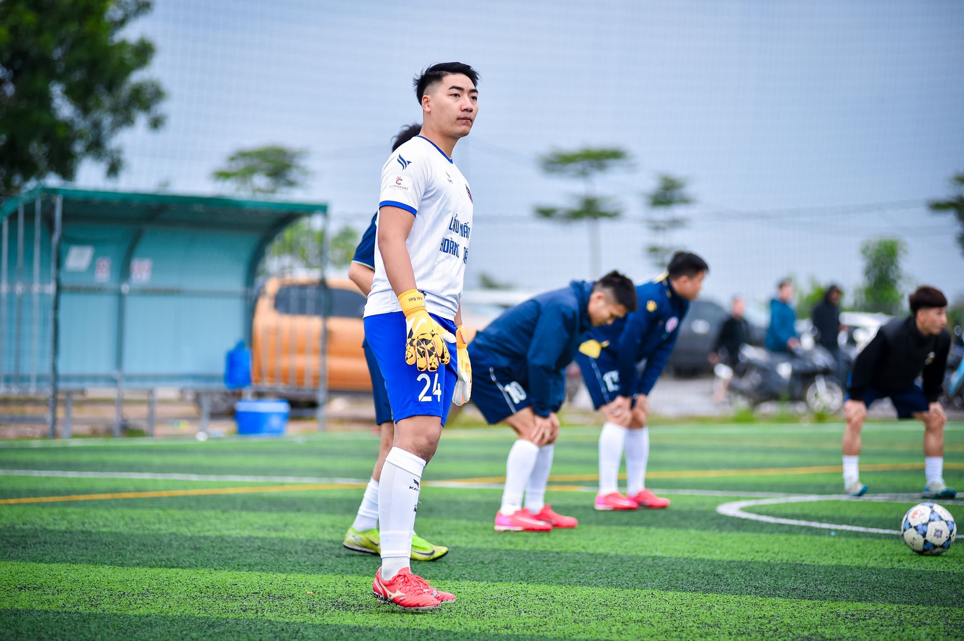 Para pemain sepak bola di lapangan rumput buatan bersiap untuk pertandingan di Hà Nội.