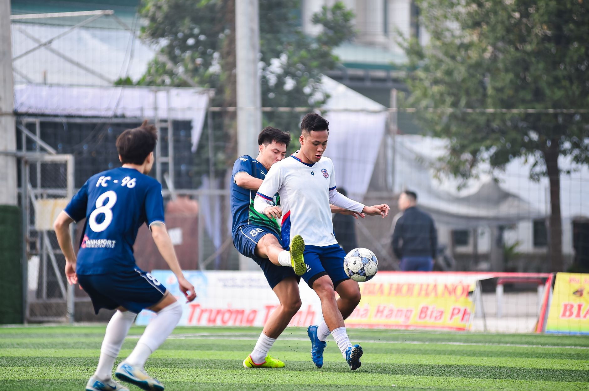 Pertandingan sepak bola seru di lapangan lokal di Hà Nội, yang menampilkan kerja sama tim dan kompetisi.