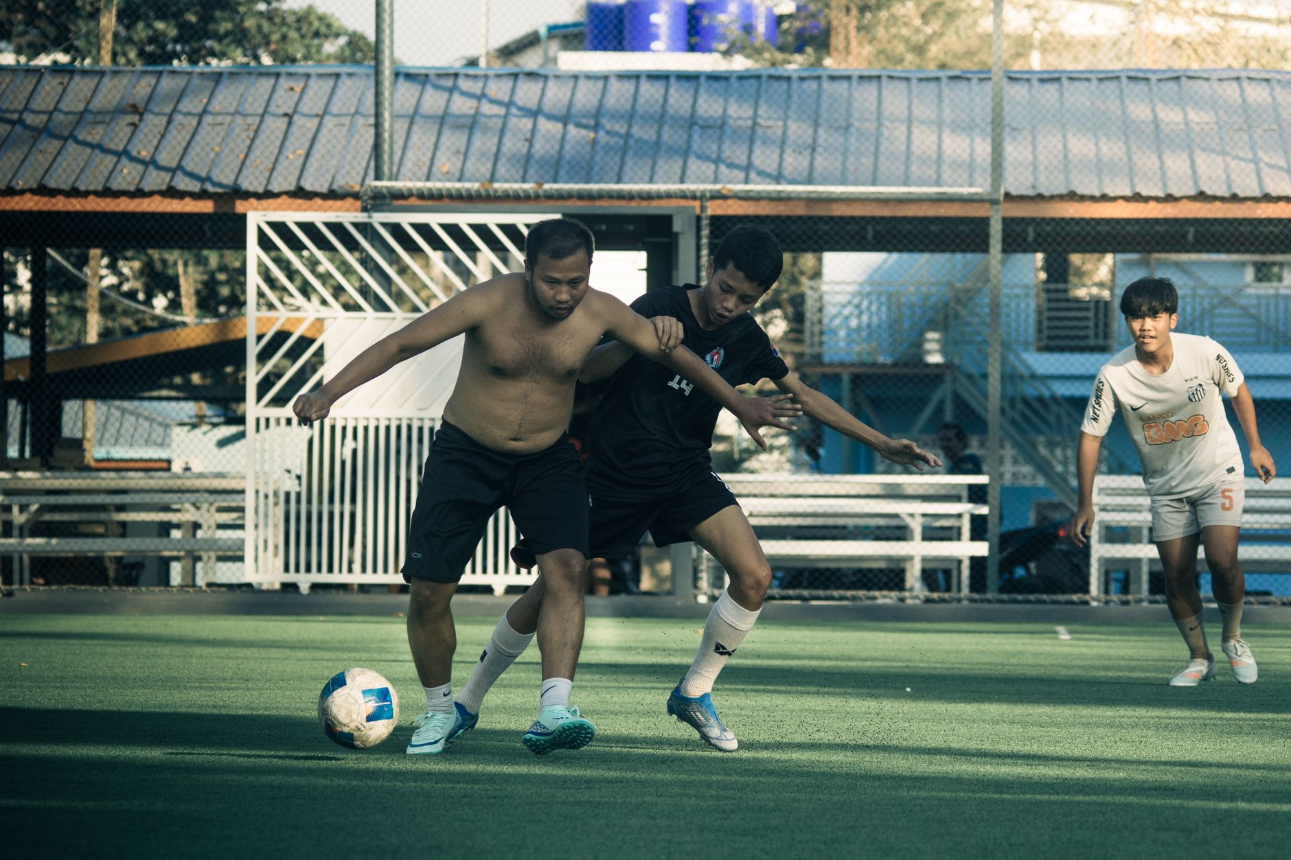 Adegan penuh aksi dari pertandingan sepak bola amatir di Myawaddy, Myanmar, yang menampilkan persaingan sengit.