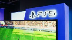 Stasiun permainan PS5 yang menampilkan pertandingan sepak bola langsung di layar, memamerkan grafis berkualitas tinggi.
