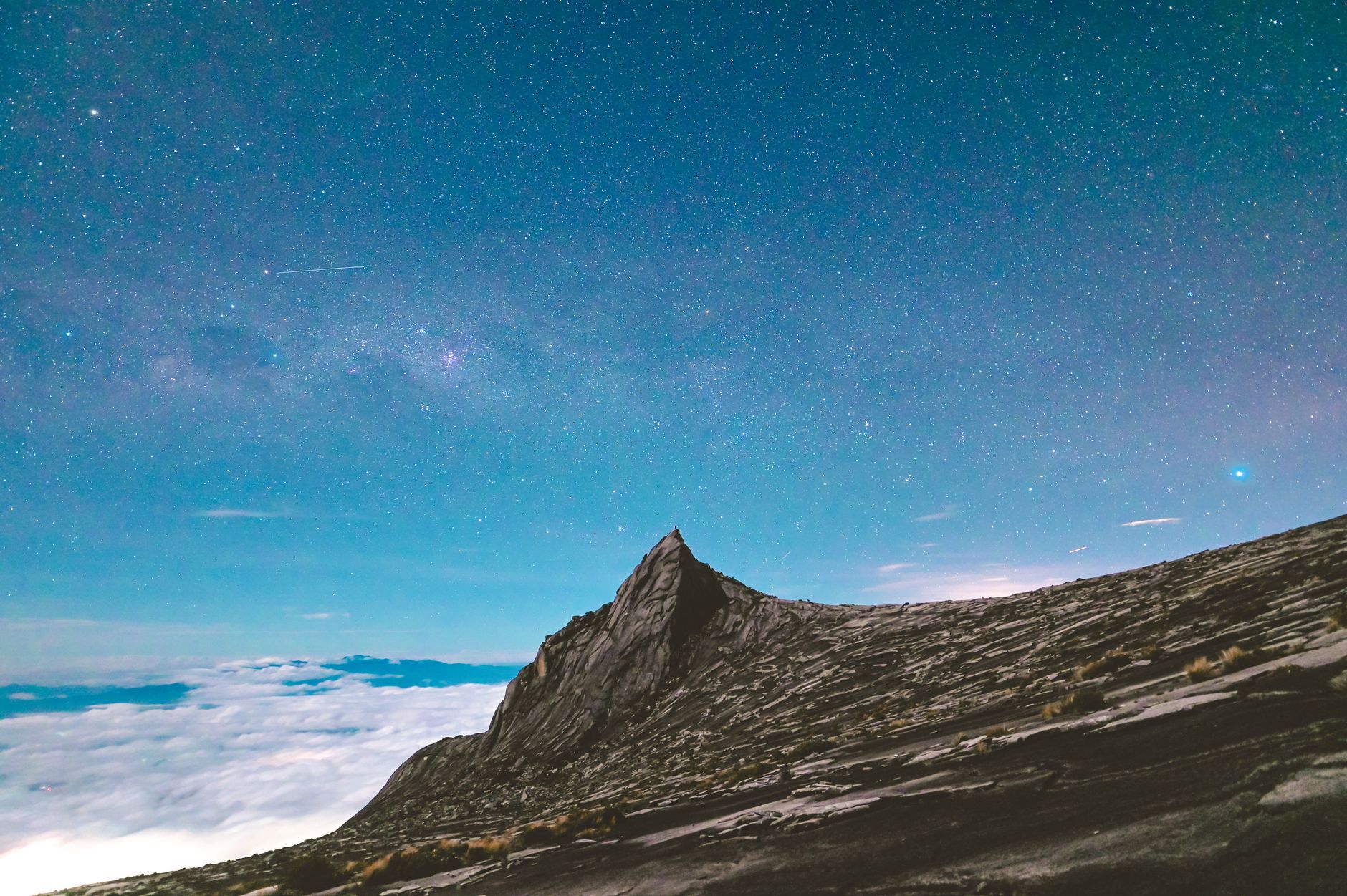 Tangkap keajaiban puncak Gunung Kinabalu melawan langit malam yang cerah dipenuhi bintang.